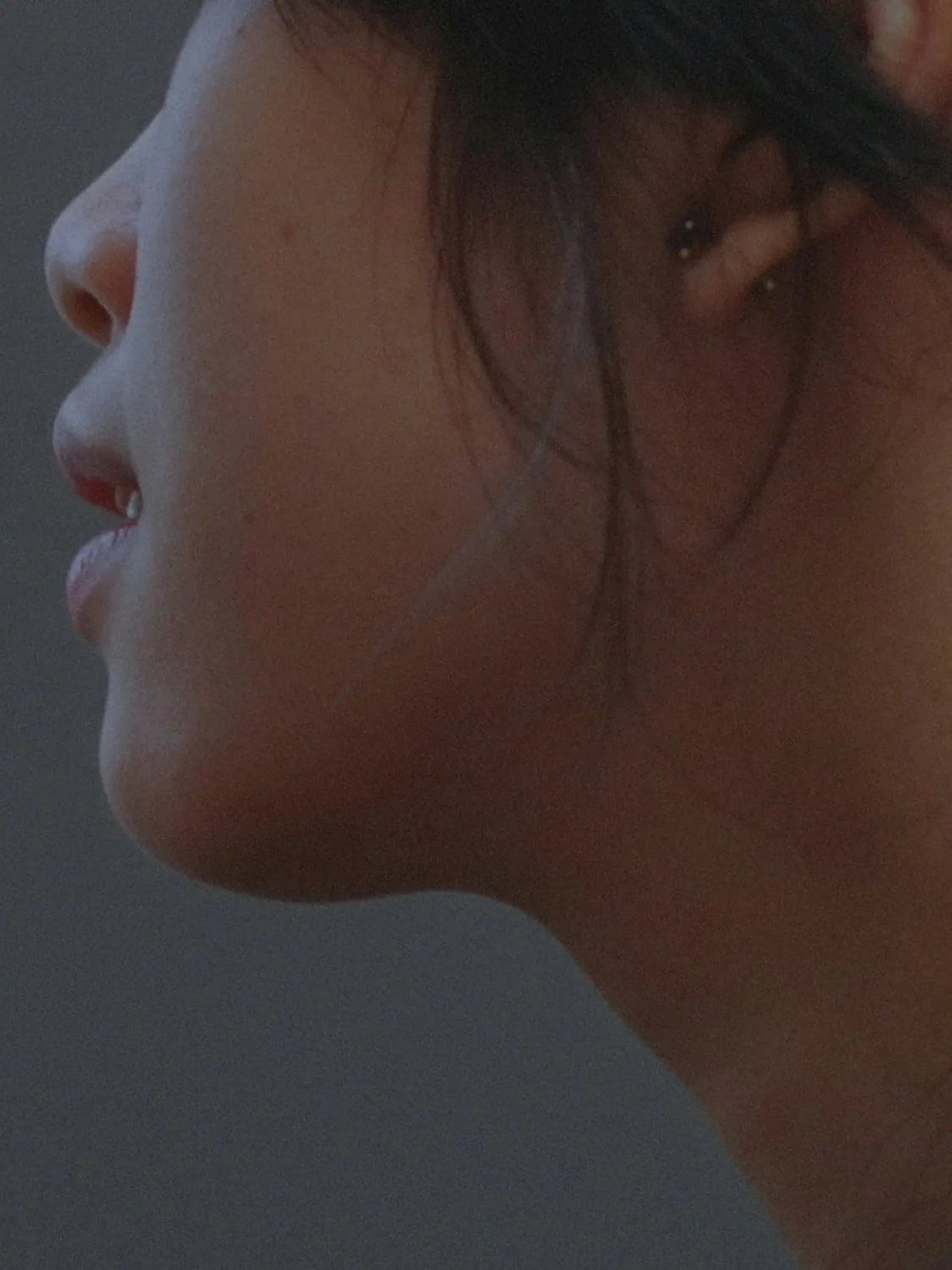 A woman in profile from the nose down, showing the line of her jaw and neck